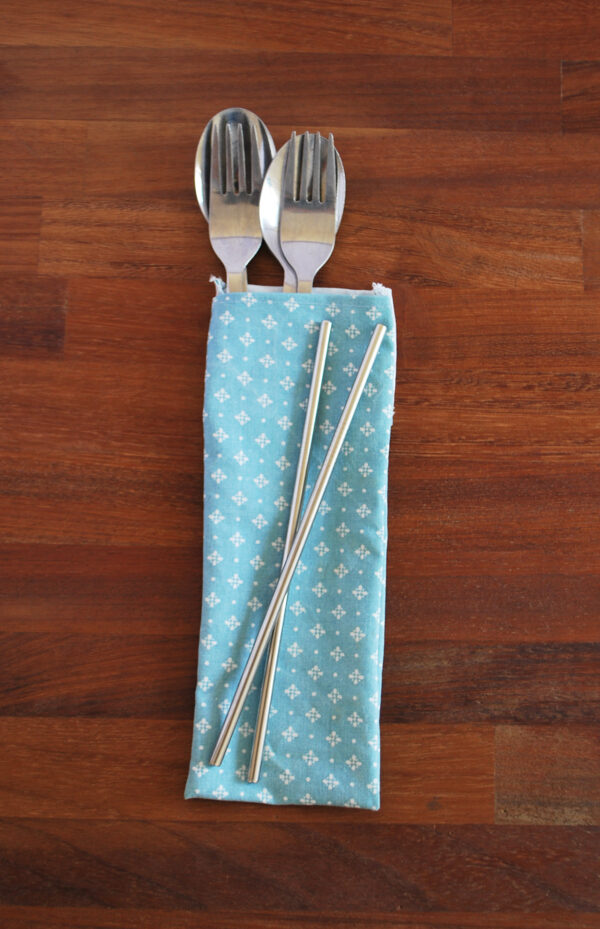 Blue diamonds cutlery pouch front with cutlery and straws on wood bg